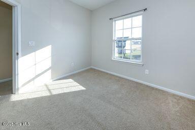 spare room featuring carpet flooring and ceiling fan