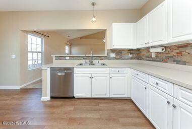 kitchen with pendant lighting, sink, dishwasher, white cabinets, and kitchen peninsula