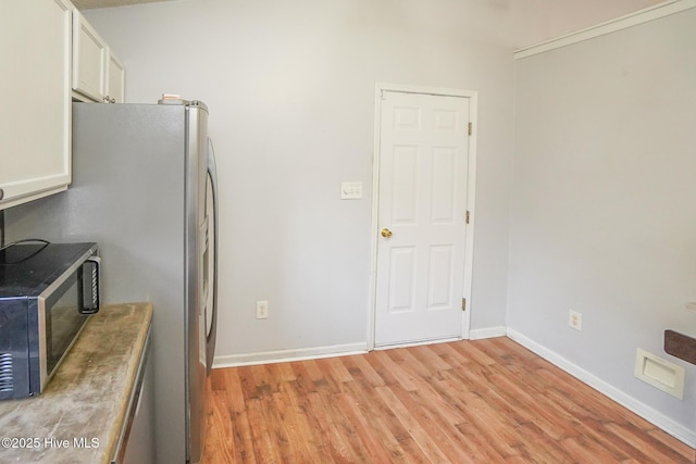 kitchen with white cabinetry, stainless steel appliances, and light hardwood / wood-style floors