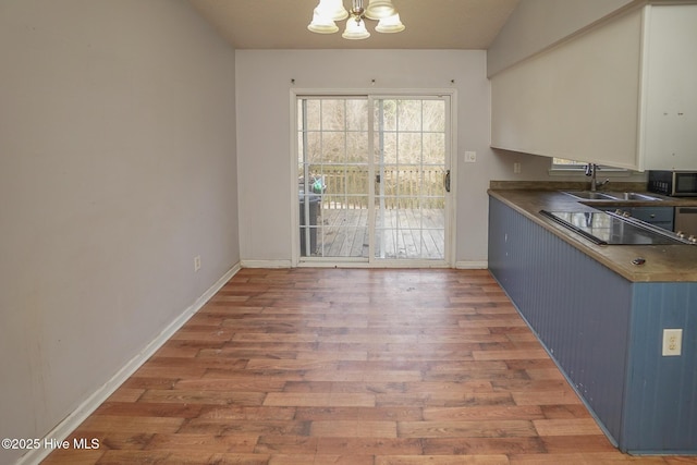 kitchen featuring dark hardwood / wood-style flooring, sink, a notable chandelier, and blue cabinets