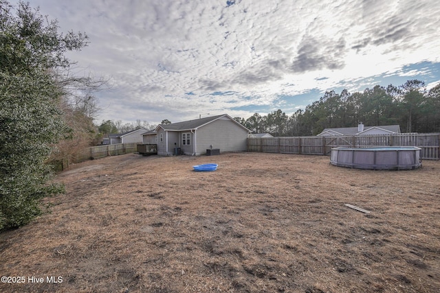 view of yard featuring a fenced in pool and central air condition unit