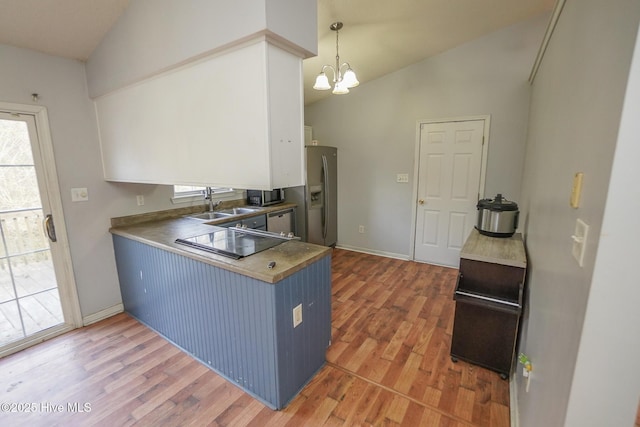 kitchen featuring vaulted ceiling, appliances with stainless steel finishes, blue cabinetry, and sink