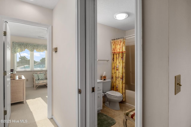 bathroom featuring a textured ceiling, shower / bath combination with curtain, and toilet