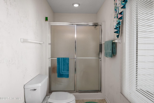 bathroom featuring an enclosed shower and toilet