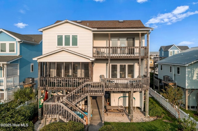 rear view of house with a sunroom, central AC unit, and a deck