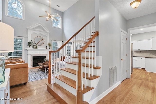 staircase featuring plenty of natural light, hardwood / wood-style floors, and ceiling fan