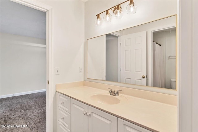 bathroom featuring vanity, walk in shower, and toilet