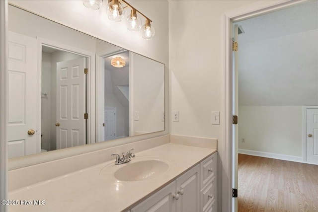 bathroom with lofted ceiling, wood-type flooring, and vanity