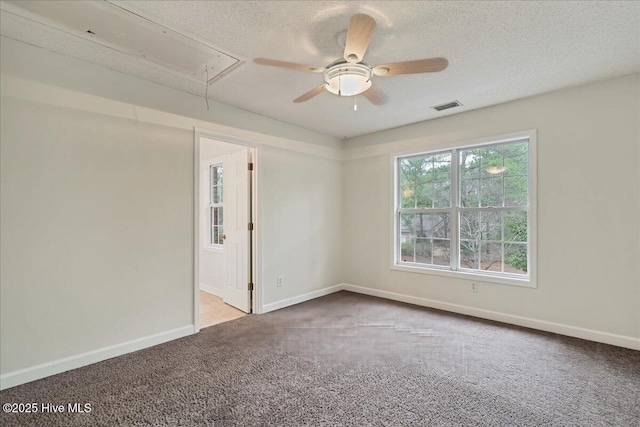 carpeted spare room featuring ceiling fan and a textured ceiling