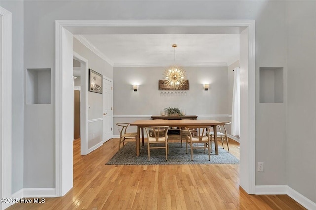 dining room featuring light hardwood / wood-style flooring, ornamental molding, and a chandelier