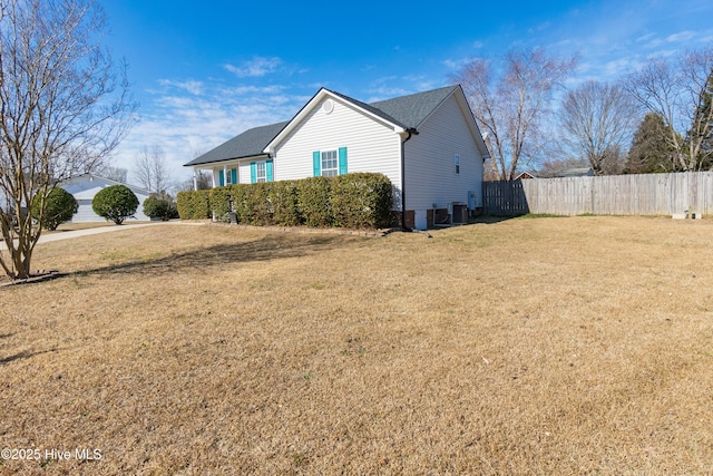 view of side of home with central AC and a lawn