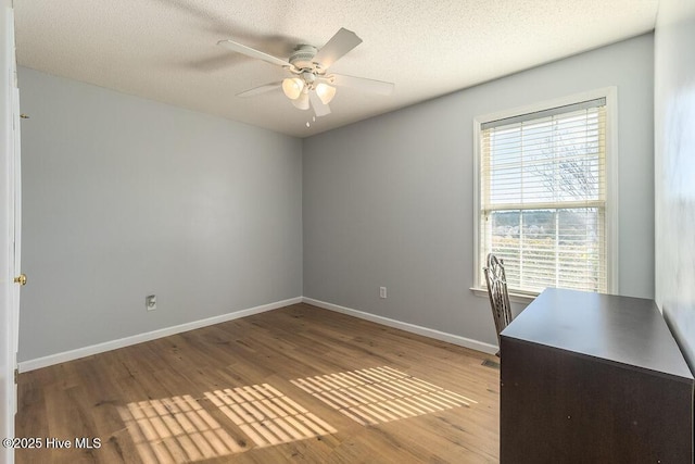 unfurnished office featuring hardwood / wood-style floors, a textured ceiling, and ceiling fan