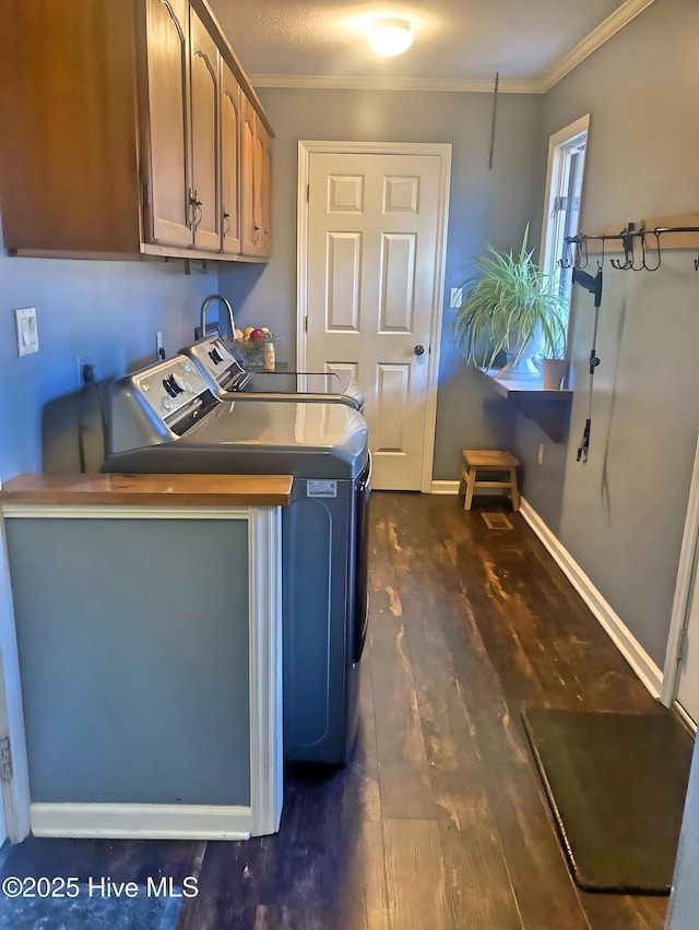 laundry room featuring separate washer and dryer, crown molding, dark hardwood / wood-style flooring, and cabinets