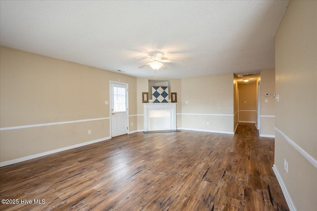 unfurnished living room with ceiling fan, a textured ceiling, and dark hardwood / wood-style flooring