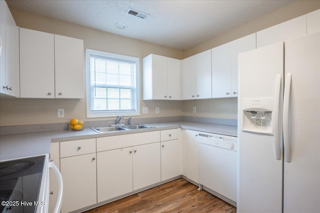 kitchen featuring white cabinetry, sink, a textured ceiling, and white appliances