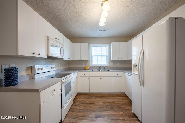 kitchen featuring white appliances, wood-type flooring, sink, and white cabinets