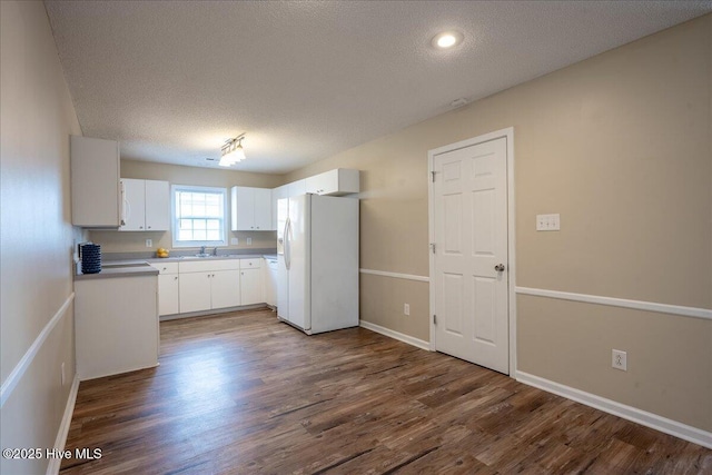 kitchen featuring white cabinetry, dark wood-type flooring, a textured ceiling, and white fridge with ice dispenser