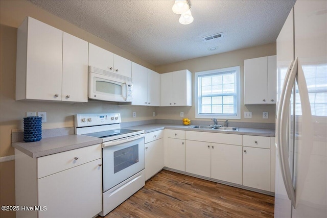 kitchen with white appliances, sink, and white cabinets