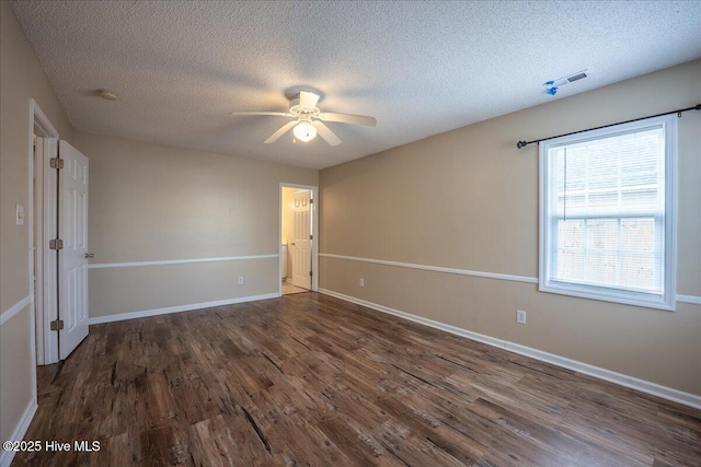 unfurnished room featuring ceiling fan, dark wood-type flooring, and a textured ceiling