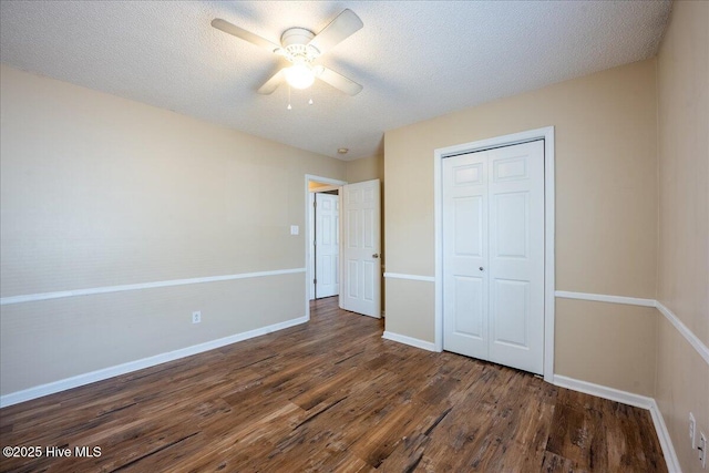 unfurnished bedroom featuring a closet, dark hardwood / wood-style floors, a textured ceiling, and ceiling fan