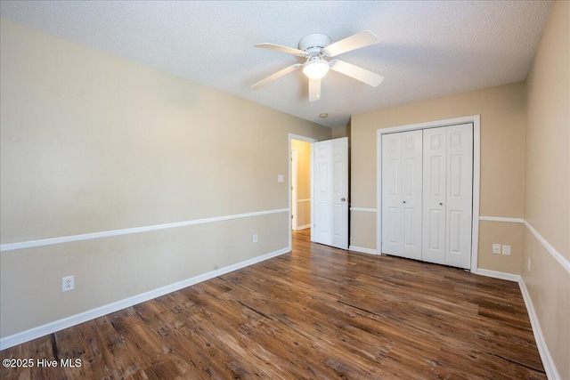 unfurnished bedroom with ceiling fan, dark wood-type flooring, a closet, and a textured ceiling