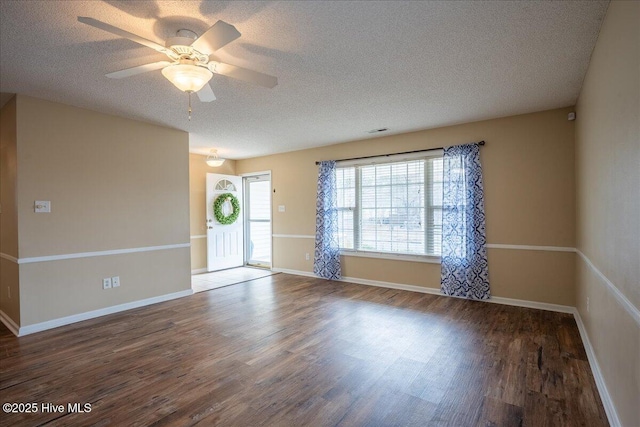 empty room with ceiling fan, dark hardwood / wood-style floors, and a textured ceiling