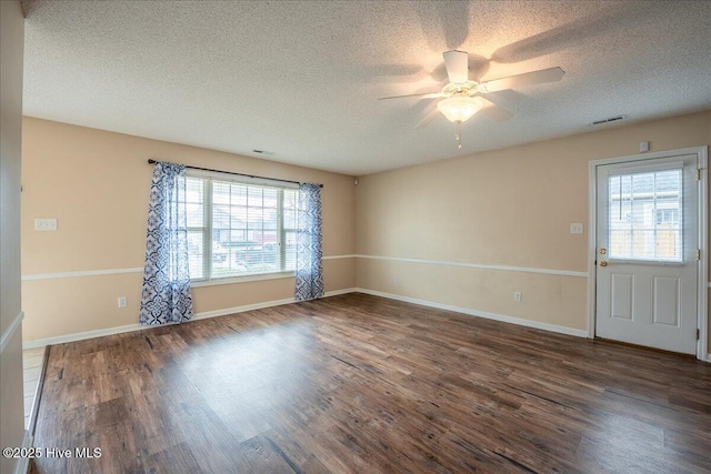 unfurnished room featuring dark wood-type flooring, ceiling fan, and a textured ceiling