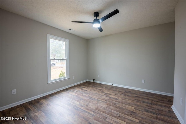 empty room featuring dark wood-type flooring, ceiling fan, and a textured ceiling