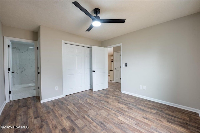 unfurnished bedroom featuring connected bathroom, a textured ceiling, dark hardwood / wood-style floors, a closet, and ceiling fan