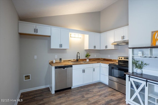 kitchen featuring lofted ceiling, butcher block counters, sink, white cabinetry, and stainless steel appliances