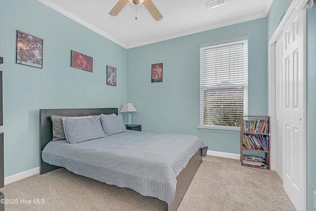 carpeted bedroom featuring ceiling fan, ornamental molding, and a closet