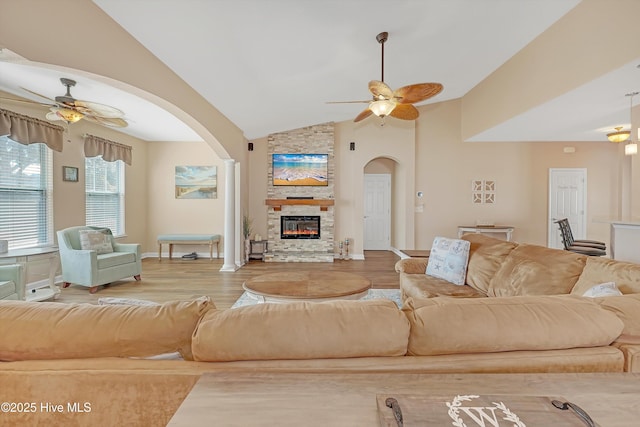 living room with ceiling fan, lofted ceiling, a fireplace, and light hardwood / wood-style flooring