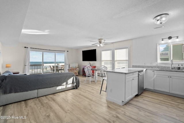 kitchen with open floor plan, visible vents, a sink, and a peninsula