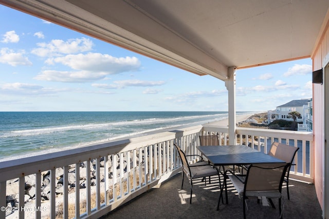 balcony featuring a water view and a beach view