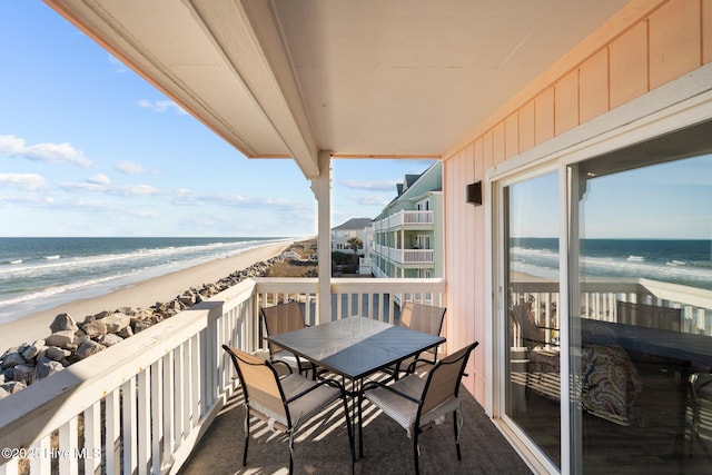 balcony with a water view and a view of the beach