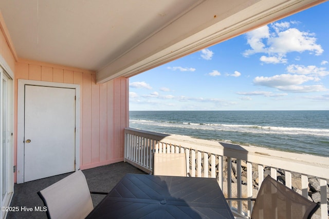 balcony featuring a water view and a beach view