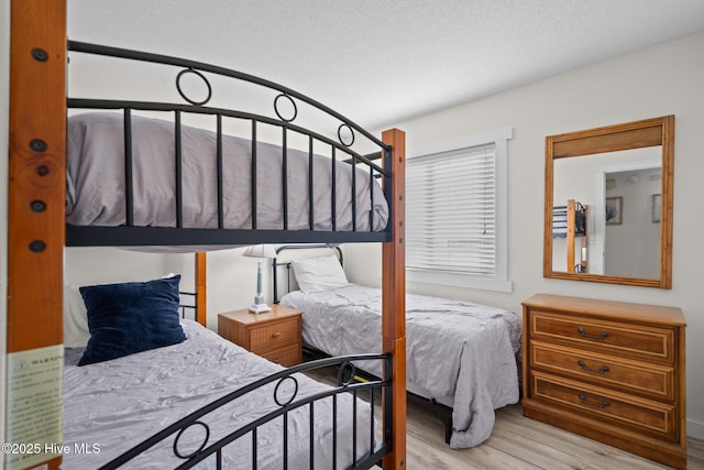 bedroom with a textured ceiling and wood finished floors