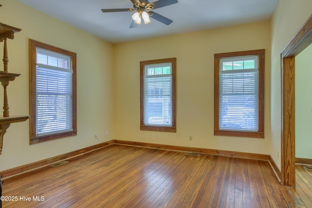 empty room with hardwood / wood-style flooring and a healthy amount of sunlight