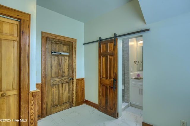 bedroom with connected bathroom and a barn door