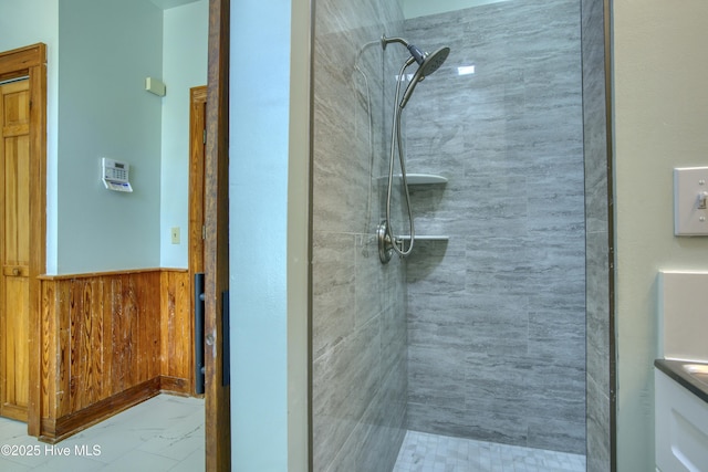 bathroom featuring tiled shower and wooden walls