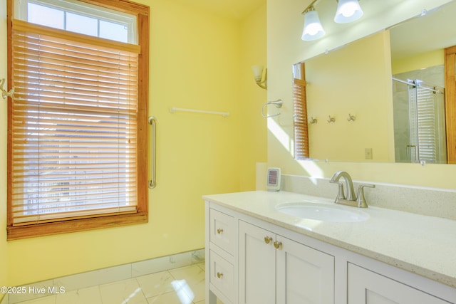 bathroom with a shower with door, vanity, and a wealth of natural light