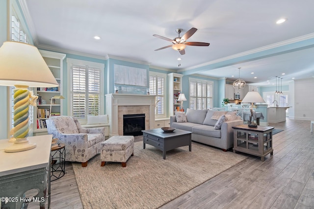 living room featuring ornamental molding, plenty of natural light, and light hardwood / wood-style flooring