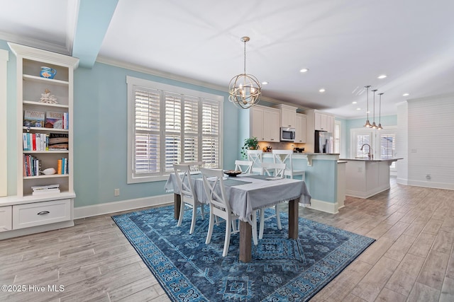 dining room with ornamental molding, light hardwood / wood-style floors, and a chandelier