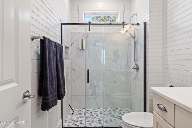 bathroom featuring toilet, vanity, and walk in shower