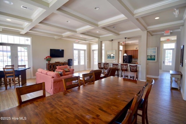 dining room with crown molding, coffered ceiling, wood-type flooring, french doors, and beamed ceiling