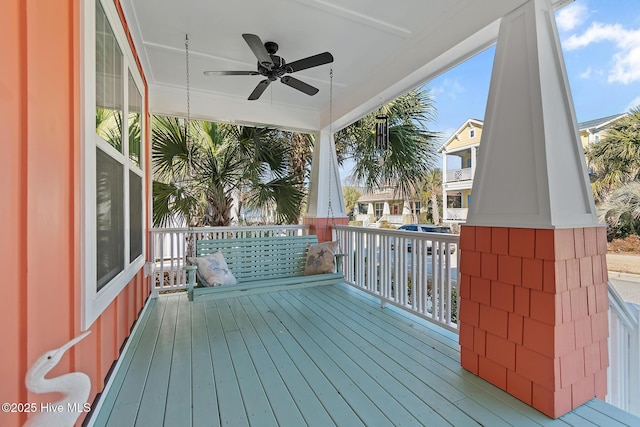 wooden terrace featuring covered porch and ceiling fan