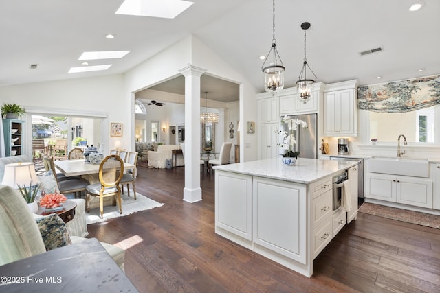 kitchen with stainless steel appliances, vaulted ceiling, a skylight, a sink, and plenty of natural light