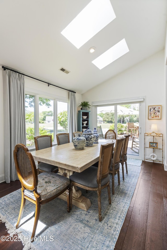dining space with a skylight, plenty of natural light, lofted ceiling, dark wood-style floors, and recessed lighting