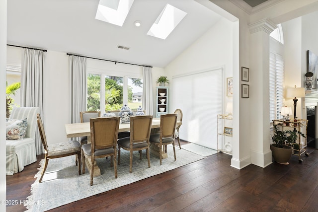 dining room featuring high vaulted ceiling, dark wood-style floors, a skylight, and baseboards