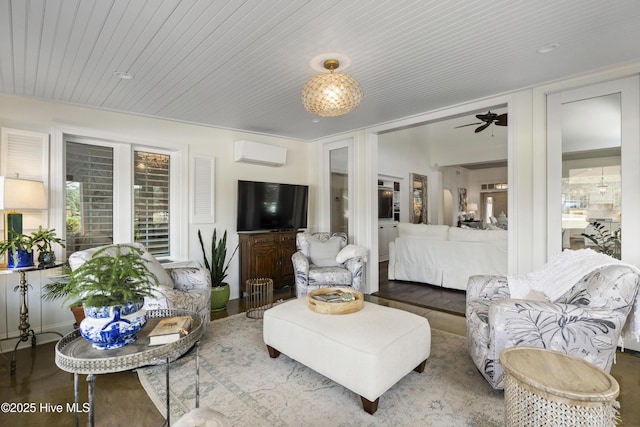 living area with an AC wall unit and ceiling fan